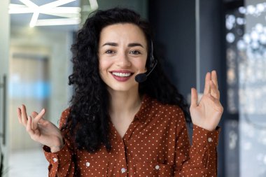 Başarılı İspanyol kadın çalışan video görüşmesinde konuşuyor, iş kadını gülümsüyor ve kameraya bakıyor, iş kadını uzaktan müşteri hizmetlerinde çalışıyor..