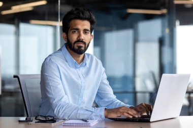 Yetişkin işadamı portresi, ciddi düşünen bir adam kameraya bakıyor, iş yerinde çalışan iş adamı iş yerinde bilgisayarını kullanıyor..