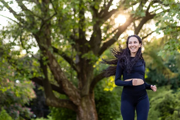 Młoda Zmotywowana Radosna Kobieta Biegająca Rano Parku Publicznym Wśród Drzew — Zdjęcie stockowe