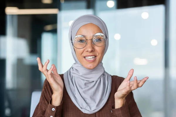 Portrait of a young Muslim woman in a hijab talking to the camera, teaching, explaining, giving advice. Close-up photo.