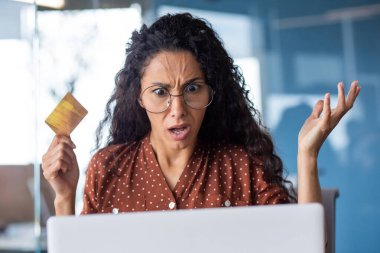 Banka kartı ve laptopuyla üzgün ve şok olmuş bir iş kadını, ofis içinde çalışan bir kadın reddedildi..