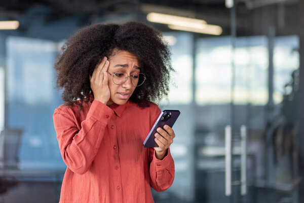 Деловая женщина получила уведомление по телефону о плохих новостях, банкротстве и потере денег, женщина на рабочем месте в офисе, используя приложение на смартфоне, разочарованы и грустно.