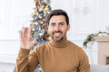 Noel 'de olgun bir adamın portresi, yeni yılı kutlamak, kameraya bakmak, evdeki oturma odasındaki kanepede oturan arkadaşlarla konuşmak, partiye davet etmek..