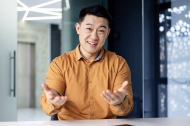 Mutlu başarılı iş adamı web kamerasından izliyor, meslektaşlarıyla uzaktan konuşan gülümseyen bir adam bilgisayardaki video çağrısını kullanıyor, ofisteki Asyalı adam.