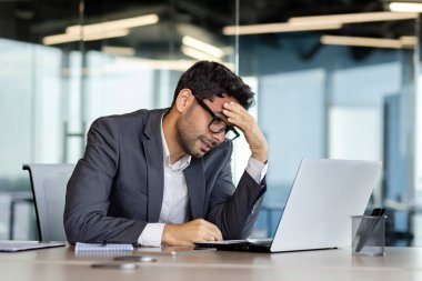 İş yerindeki depresyon, başarı yüzünden hayal kırıklığına uğrayan işadamı ofiste umutsuzluğa kapılır, takım elbiseli adam dizüstü bilgisayarla çalışmaktan mutsuz olur..