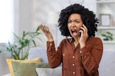 Hüsrana uğramış ve kızgın bir kadın telefonda konuşuyor, Afrikalı Amerikalı kadın bağırıyor ve müfettişe kızgın, evin oturma odasındaki kanepede yalnız oturuyor..
