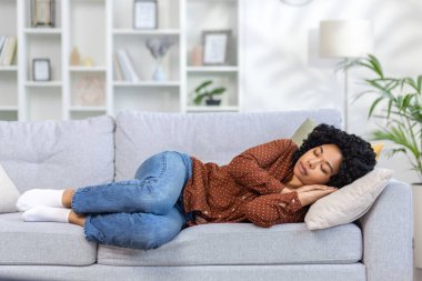 Genç, güzel bir kadın işten sonra evde dinleniyor, Afro-Amerikalı bir kadın uyuyor oturma odasında kanepede uyuyor, gündüzleri kestiriyor..