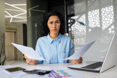 Kameraya bakan mutsuz bir kadın, elinde raporlar tutan bir iş kadını, mali sözleşmeler tutan bir kadın ofis içi çalışan evrak işleri, kontrol ve analiz yapan bir kadın..