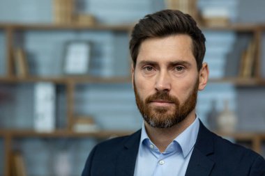 Ofis ortamında sakallı, ciddi, olgun bir iş adamı. Tecrübe, otorite ve profesyonellik aktarımı..