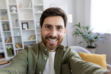 Tişörtlü, beyaz bir erkeğin dijital kamerayla video kaydını ilk gören kişi. Popüler etkileyici, sosyal medyada yeni bir içerik ve evden kişisel blogda yeni bir yazı üretiyor.