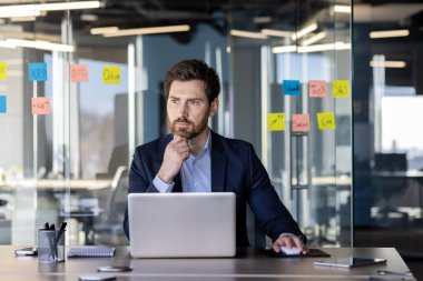 Cama yapışkan notlar yapıştırarak modern bir ofiste çalışan olgun bir iş adamı. Liderlik ve profesyonellik kavramı.