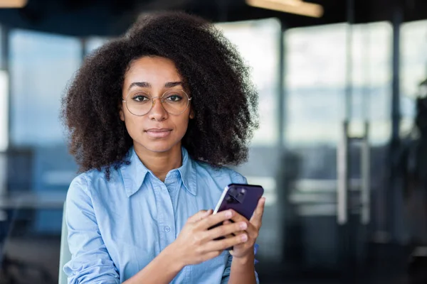 Bir televizyon sunucusu, bir etkinlik sırasında bir elektrikli mavi cep telefonunu, taşınabilir bir iletişim cihazını zarifçe tutarken görülüyor..