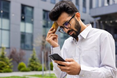 Ofis dışında hayal kırıklığına uğramış üzgün bir adam uyanıyor elinde telefon ve banka kartı olan genç bir işadamı para transferini, dolandırıcılığı ve aldatmacayı engelliyor..