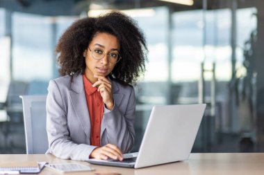 Tablet ve defterin yanında taşınabilir bilgisayarın yanında çalışırken düşünceli bir Latin kafa üstü dinleniyor. Düşünceli kadın patron, hangi çalışanın liderlik pozisyonuna terfi etmeyi hak ettiğine karar veriyor..