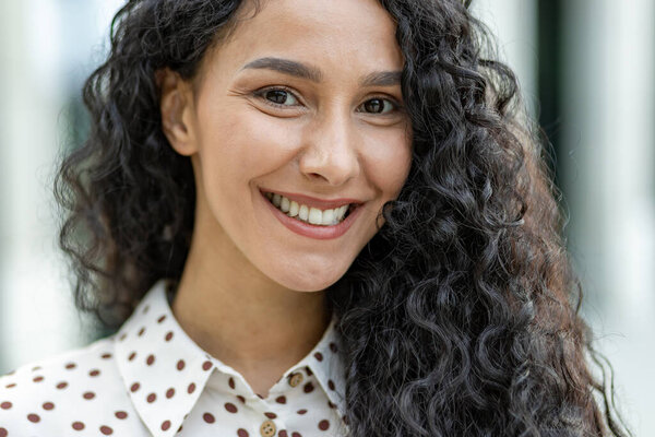 A detailed image showcasing the texture and pattern of curly hair and a polka-dotted garment. The soft focus gives the picture a delicate and stylish look suitable for diverse uses.
