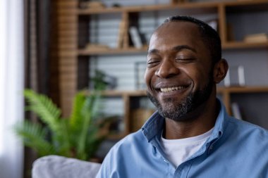 Afro-Amerikan erkek evde huzurlu bir anın tadını çıkarıyor, mutluluk ve sükunet yayıyor..