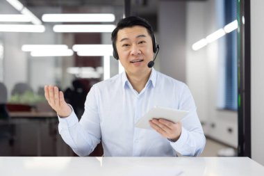 Kulaklığı olan arkadaş canlısı çağrı merkezi operatörü modern bir ofiste mükemmel müşteri hizmetleri sunuyor..