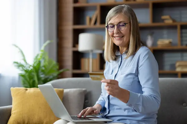 Ώριμη Γυναίκα Γυαλιά Χαμόγελα Καθώς Χρησιμοποιεί Ένα Φορητό Υπολογιστή Για Royalty Free Εικόνες Αρχείου