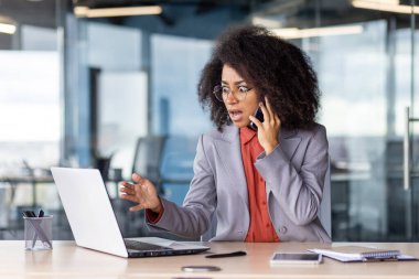 Portatif bilgisayar ekranına yuvarlak gözlerle bakarken cep telefonuyla konuşan korkunç bir kadın. Öfkeli siyahi kadın iş ortağından acil haberler alırken çaresiz kalıyor..
