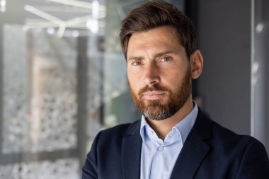 Ofis ortamında takım elbiseli profesyonel bir erkek yönetici güven ve liderlik yayıyor..