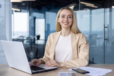 İş yerindeki gülümseyen profesyonel bir kadının portresi kurumsal bir ortamda, kameraya bağlanıyor..
