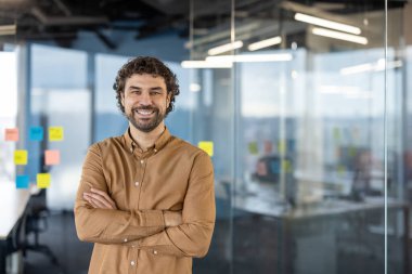 Kendine güveni tam bir İspanyol erkeği. Sıcak bir gülümsemesi var. Modern ofis ortamında öylesine duruyor ve dostça bir profesyonellik sergiliyor..
