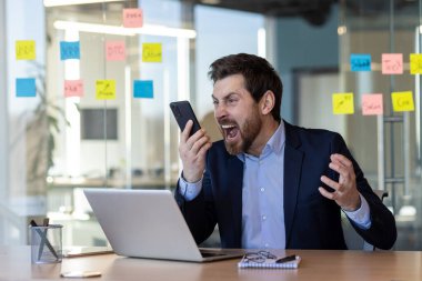 Kızgın patron tacizcisi telefonda konuşuyor. Takım elbiseli adam bağırıyor. İş yerinde iş yerinde sohbet ediyor..