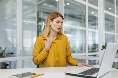Heat and heat in the office, tired overheated business woman working on a laptop, broken air conditioner in the workplace, lack of fresh air.