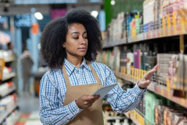 Mağaza envanterini yönetmek için dijital tablet kullanan bir satıcı. Ürün bilgilerinin düzenlenmesi ve kaydedilmesine odaklanıldı.