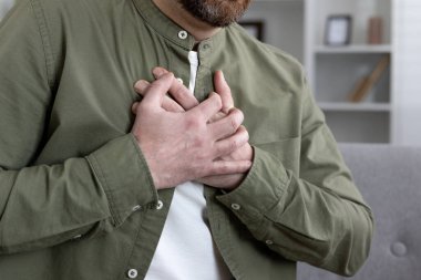 Göğüs kafesinde kalp ağrısı ya da kalp krizi geçiren bir adama yakın çekim. Sağlık sorunları, göğüs ağrısı ve kardiyovasküler sorunlar. Acil durum ve tıbbi yardım gösteriyor..