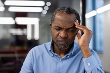 Stres yaşayan bir iş adamı, iş yerinde hayal kırıklığı yaşıyor. Profesyonel olarak mavi gömlek giymek zihinsel yorgunluk ve ofis sorumluluklarının yükü, stres ve gerilimi taşır.