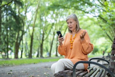 Parktaki bankta oturan olgun bir kadın, akıllı telefonuyla meşgul. Kafası karışmış ya da hayal kırıklığına uğramış gibi görünüyor. Arka planda sakin bir açık hava ortamını tasvir etmek, teknolojiyi, yaşlanmayı ve duyguları yakalamak.