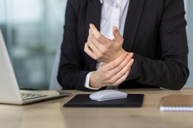 Ofisteki iş kadını, bilgisayar kullanımından dolayı bileği ağrıyormuş. İş sağlığı, ergonomik sorunlar ve bilgisayar gerilimi kavramı. Ortak ofis işleri zorluklarını vurgular.