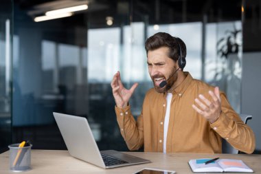 Modern ofisteki iş adamı, kulaklıklı dizüstü bilgisayar kullanarak çağrı sırasında hayal kırıklığını dile getiriyor. Konseptler arasında stres, teknoloji sorunları, iletişim sorunları yer alıyor. İdeal iş dünyası duygusal stres temaları