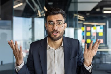 Takım elbiseli olgun bir iş adamı, bir iş görüşmesi sırasında şaşkın ve anlamlı bir tepki gösterir. Profesyonel ortam iletişim, karar verme mekanizması ve işbirlikçi kavramlar önermektedir.