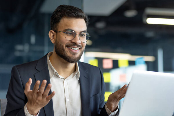 Зрелый профессиональный бизнесмен, участвующий в онлайн-дискуссии на ноутбуке. Подчеркивает уверенность и современные корпоративные коммуникации. Идеально подходит для отображения деловых взаимодействий