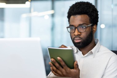İş görüşmesi internet konferansı, not defteri ile yakın çekim, veri yazma ve uzaktan çalışma bilgisayarlı, işadamı internetten webinar yayınını izliyor..