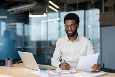 Muhasebeci portresi, evrakların arkasında gülümseyen ve kameraya bakan bir adam, elinde kontrat ve vergi formu tutan bir iş adamı, bilanço doldurup,.