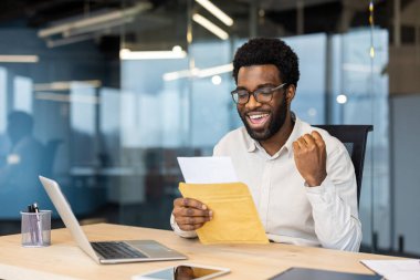Elinde posta zarfı tutan başarılı bir işadamı, başarılı sonuç içeren bir uyarı mektubu aldı. El ele tutuşup zaferi kutlayan bir adam..