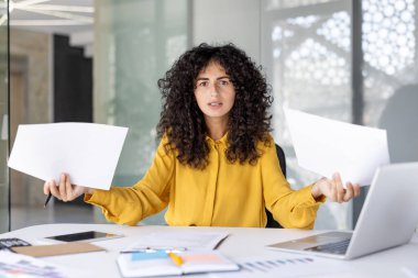 İş yerindeki kafası karışmış ve hayal kırıklığına uğramış bir kadının portresi ellerinde belgeler ve kağıtlarla. Kameraya bakan finansör başarılardan memnun değil, kötü raporlar.