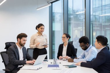 Başarılı iş adamları, iş kadınları ve iş adamları konferans masasında konuşan, işbirliği yapan, memnun ve gülümseyen çalışanlar..