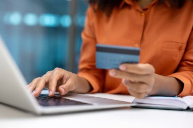 Kadının eli banka kartı ve dizüstü bilgisayarla çevrimiçi alışveriş, online rezervasyon hizmetleri.