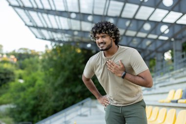 Çok çalışan ve aşırı yorgun koşucu aktif fiziksel egzersiz yaparken ve temiz havada koşarken, adam göğsüne tutunuyor, şiddetli kalp ağrısı, kalp krizi geçiriyor..