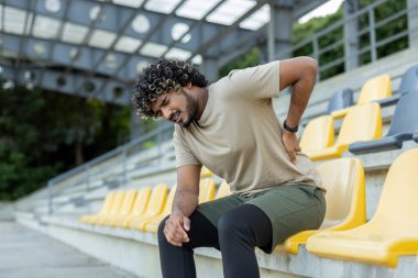 Sporcu sırt ağrısından muzdarip, koşu yaparken ve aktif fiziksel egzersiz yaparken ve spor yaparken yaralanmış..