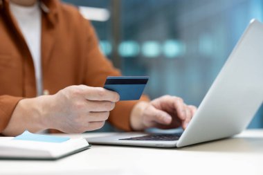 Bir kişi online alışveriş veya iş için dizüstü bilgisayar ve kredi kartı kullanır. Çevrimiçi bankacılık, e-ticaret ve güvenli işlemler kavramları.