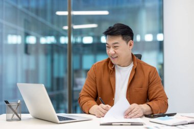 Ofisteki sanal iş konferansı sırasında bir finansör gülümsüyor.