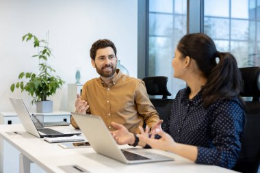 İki meslektaşın bir toplantı sırasında canlı bir sohbete girişip takım çalışmasını sergiledikleri samimi bir an..