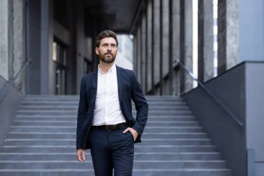 İyi giyimli bir işadamı, şehir ortamında profesyonellik ve başarı yayarak, güvenli bir şekilde merdivenlerden aşağı iner..