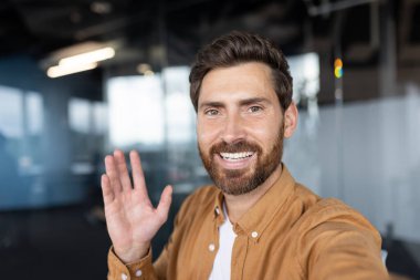 Ofis ortamında arkadaşça karşılama, muhtemelen sanal toplantı ya da sohbet sırasında..