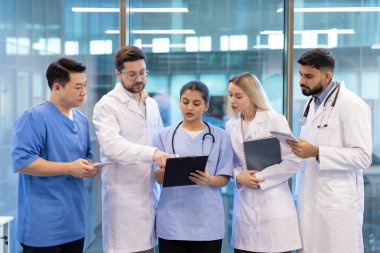 Profesyonel bir ortamda sağlık ekibi belgeleri gözden geçirir ve hasta teşhisi konusunda işbirliği yapar..